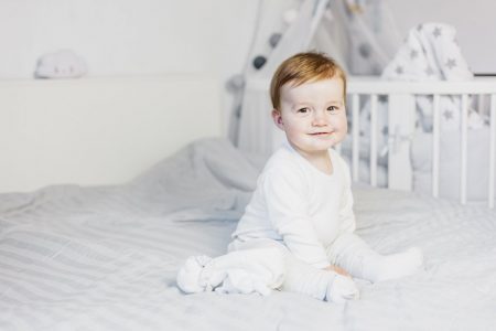 Cute baby boy on bed - Top 100 baby names in Iceland