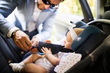 Dad putting baby in a rear-facing car seat