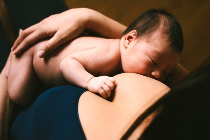 Mom breastfeeding a newborn baby with dark hair