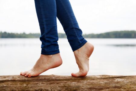 Woman barefoot walking on a log